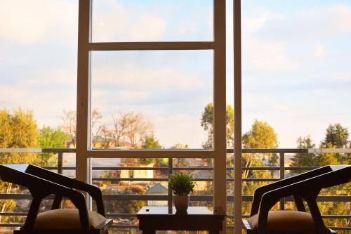 a room with a window and two chairs and a table at SERENE SUITES in Dharamshala