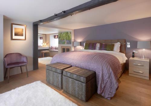 a bedroom with a large bed and a purple wall at The Dog and Badger in Marlow