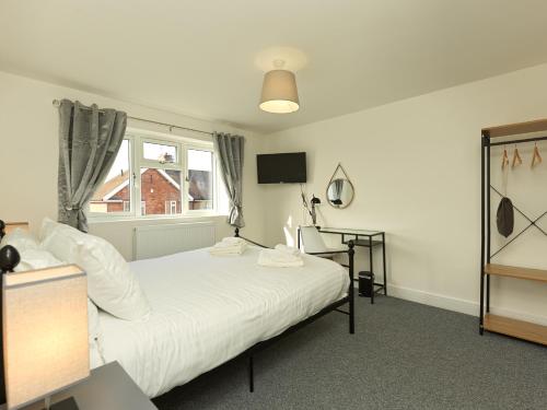 Un dormitorio con una gran cama blanca y una ventana en Shrewsbury Townhouse with Parking en Harlescott