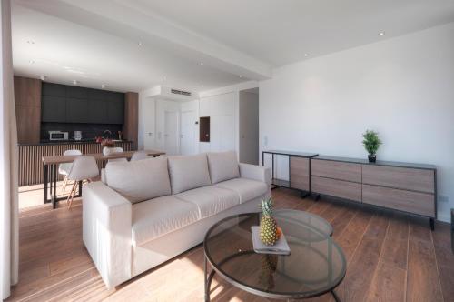 a living room with a white couch and a table at Horizon Two bedroom Penthouse with Hot tub in Becici