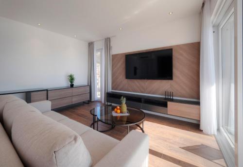 a living room with a couch and a tv at Horizon Two bedroom Penthouse with Hot tub in Becici