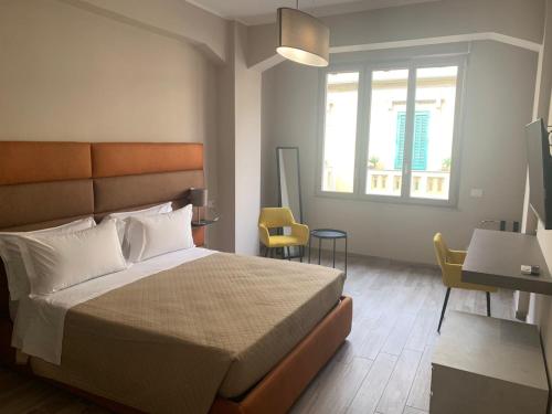 1 dormitorio con cama, escritorio y ventana en Tripepi suites, en Reggio Calabria