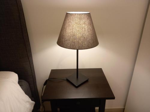 a lamp sitting on a table next to a bed at Lopes Apartment - Belch1952 in Lagos