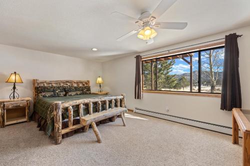 een slaapkamer met een bed en een plafondventilator bij Lily Mountain Lodge - Amazing Mountains Views, Private Hot Tub, Great Location in Estes Park