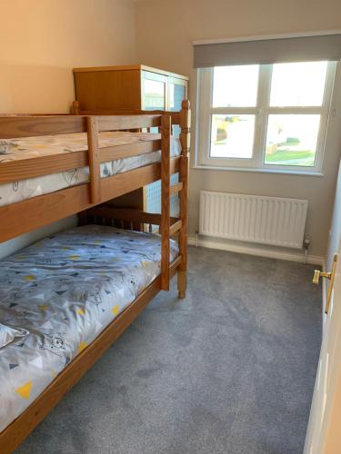 ポーツチュワートにあるMillfield Holiday Villageのベッドルーム1室(二段ベッド2台、窓付)が備わります。