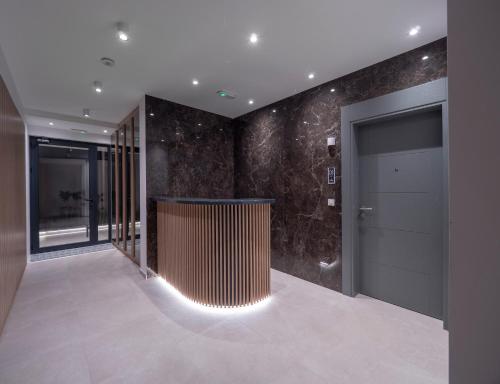 a hallway with a door and a wall of stone at Horizon Two bedroom Penthouse with Hot tub in Becici