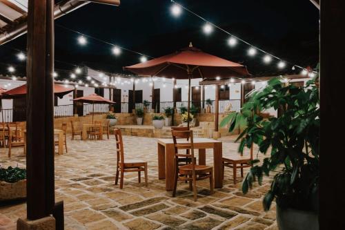a restaurant with tables and chairs and umbrellas at Don Juan De Dios De Guane Hotel & Centro De Convenciones in Barichara