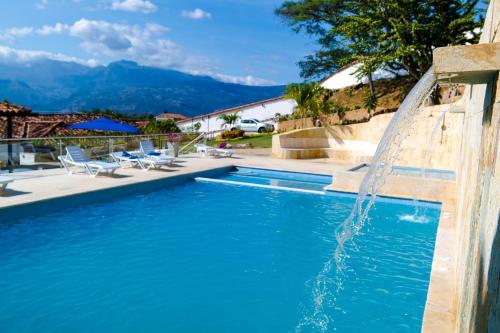 a swimming pool with a water fountain at Don Juan De Dios De Guane Hotel & Centro De Convenciones in Barichara
