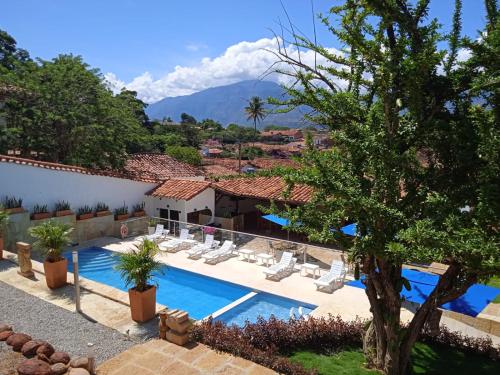 a resort with a pool and chairs and a mountain at Don Juan De Dios De Guane Hotel & Centro De Convenciones in Barichara