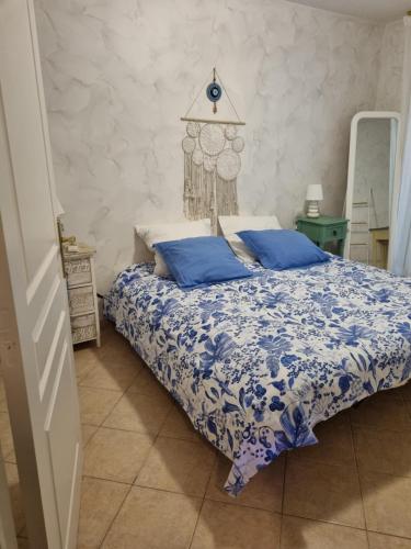 une chambre avec un lit avec une couette bleue et blanche dans l'établissement Le jardin de Bonporteau, à Cavalaire-sur-Mer