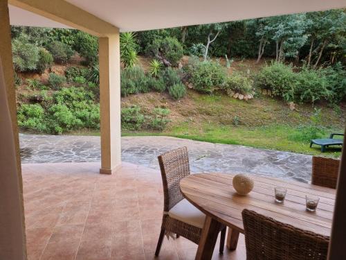 d'une terrasse avec une table et des chaises en bois. dans l'établissement Le jardin de Bonporteau, à Cavalaire-sur-Mer