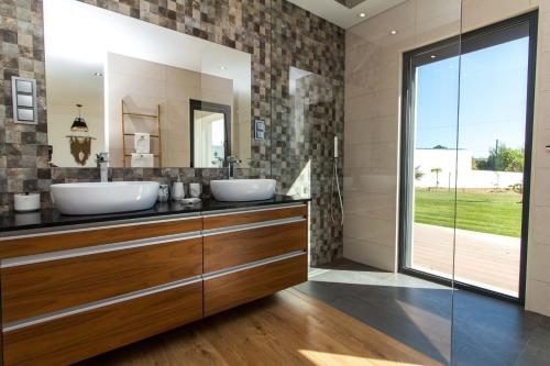 ein Badezimmer mit zwei Waschbecken und einem großen Spiegel in der Unterkunft Villa Videira By Dalma Portuguesa - By Dalma Portuguesa in Sesmarias