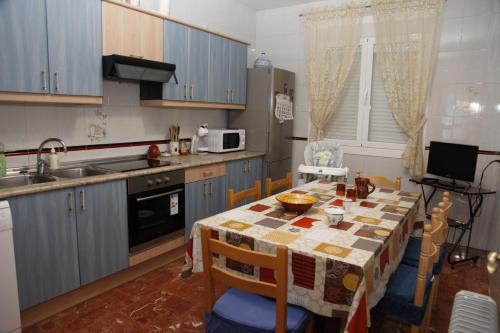a kitchen with a table and a kitchen with blue cabinets at VUT Flor de Romero in Los Yébenes