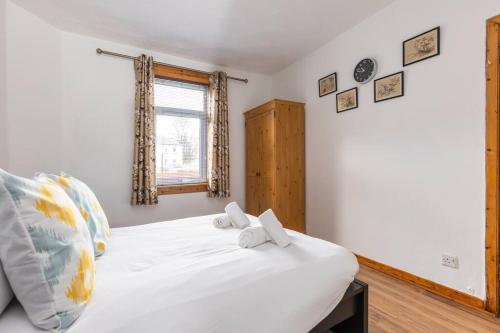 a bedroom with a white bed and a window at Beautiful 2 bedroom flat in Edinburgh in Edinburgh