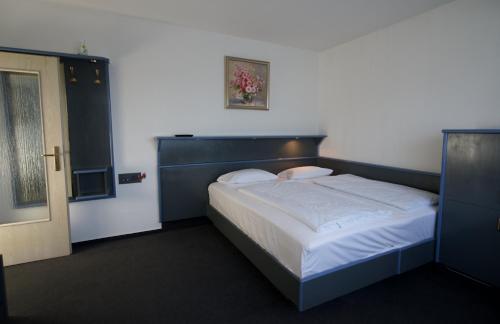 une chambre avec un grand lit et une tête de lit bleue dans l'établissement Hotel Merian, à Cologne