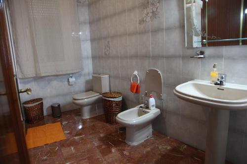 a bathroom with a sink and a toilet and a sink at VUT Flor de Romero in Los Yébenes