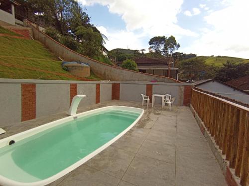 a bath tub sitting on top of a patio at Pousada Da Santina in Visconde De Maua