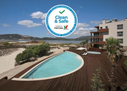a swimming pool at a resort with a sign that reads clean and safe at Troia - Paraíso a um passo de Lisboa in Troia