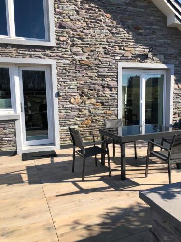 a table and two chairs in front of a stone building at PEGASUS I - 2 chambres de luxe, cuisine, salon, 2 terrasses et sauna in Vielsalm