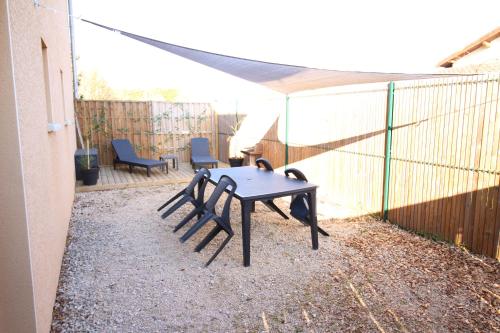 un patio avec une table et des chaises et une clôture dans l'établissement Appartement T1 tout confort au Lac du Der, à Giffaumont
