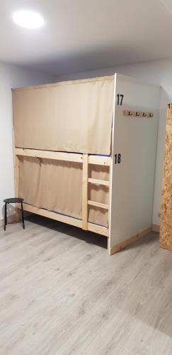 een kamer met een bed en een kast met een muur bij Albergue Santos in Santiago de Compostela