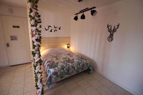 a bedroom with a bed with flowers on it at Appartement T1 tout confort au Lac du Der in Giffaumont