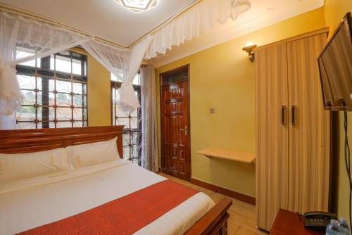 a bedroom with a bed and a window at Mlex Hotel in Kampala