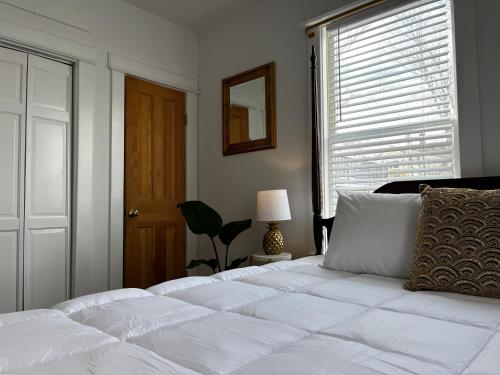 a white bed in a bedroom with a window at Queen Anne's Revenge in Bar Harbor