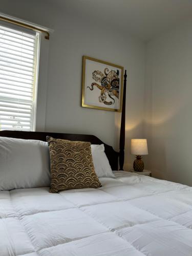 a white bed with a pillow and a picture on the wall at Queen Anne's Revenge in Bar Harbor