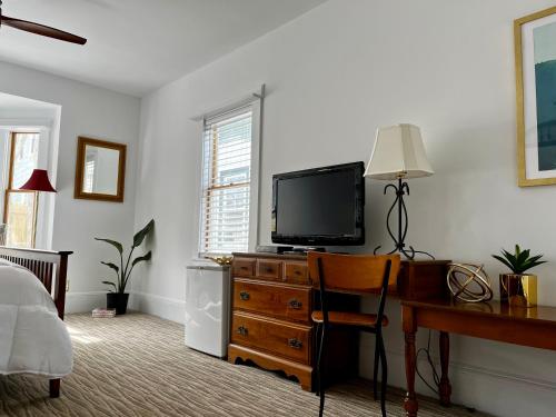 a bedroom with a desk and a flat screen tv at Queen Anne's Revenge in Bar Harbor
