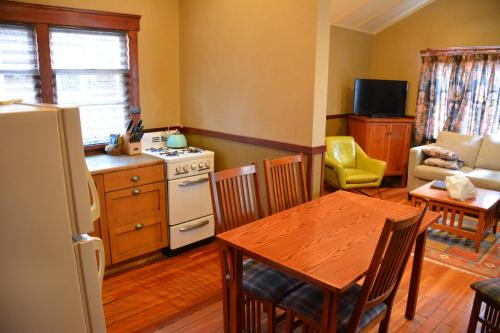 a kitchen and living room with a table and a refrigerator at Johnston Canyon Lodge & Bungalows in Castle Junction