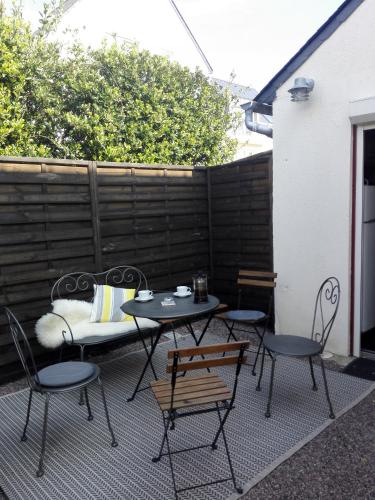a patio with a table and chairs and a bench at Les îles, le bourg, la plage in Ploubazlanec