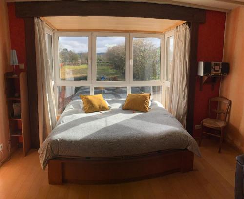 een bed in een kamer met een groot raam bij Maison la Gileppe in Jalhay