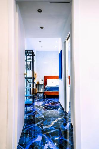 a hallway with blue tiled floors and a bed at Marmur luxury room in Lecce