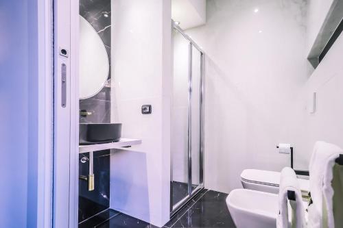 a bathroom with a toilet and a glass shower at Marmur luxury room in Lecce