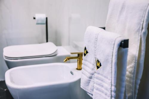 a bathroom with a sink and a toilet and towels at Marmur luxury room in Lecce