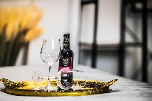 a bottle of wine and glasses on a gold plate at Marmur luxury room in Lecce