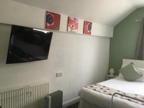 a bedroom with a bed with a flat screen tv on the wall at The Address in Blackpool