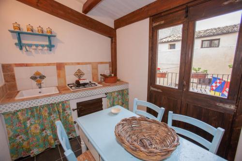 a kitchen with a table and a sink and a window at SI-Moutique Le Case degli Avi barocche, con terrazza panoramica in Modica