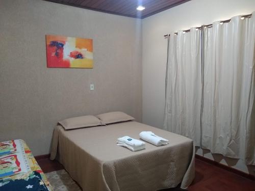 1 dormitorio con 1 cama con 2 toallas en Pousada do Ribeirão, en Andrelândia