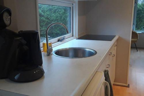 a kitchen counter with a sink and a window at Chalet op mooie rustige plek in Enschede