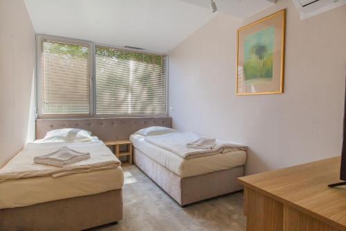 Pokój z 2 łóżkami, stołem i oknem w obiekcie Imperiall Resort&MediSPA-DOMKI PREMIUM w Sianożętach
