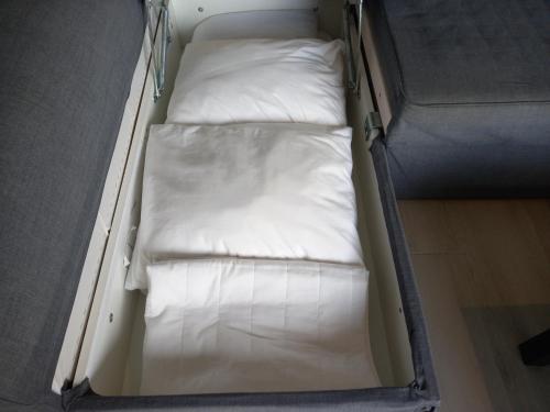 een klein bed met witte kussens in een kamer bij BELCH1952 in Lagos