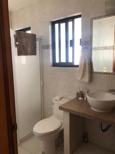 a bathroom with a toilet and a sink and a mirror at Amplio y cómodo al Sur de Zapopan in Guadalajara