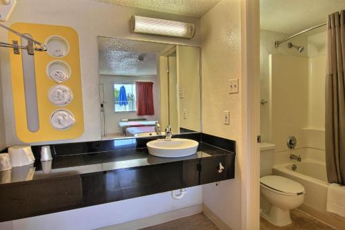 a bathroom with a sink and a toilet and a mirror at Motel 6-Austin, TX - North Central in Austin
