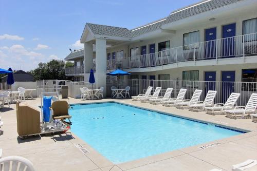 a large swimming pool with chairs and a hotel at Motel 6-Austin, TX - North Central in Austin