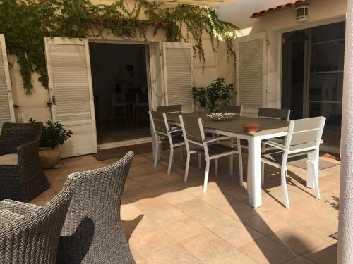y un patio con mesa de comedor y sillas. en Le cabanon, en Antibes
