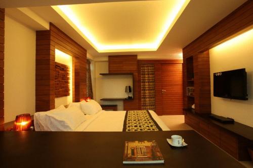 a hotel room with a bed and a tv at Baannueng at Aree 5 Hotel in Bangkok