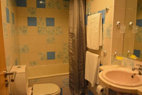La salle de bains est pourvue de toilettes, d'un lavabo et d'une baignoire. dans l'établissement Wonderful Apartment Albufeira Marina 4B 2B, à Albufeira