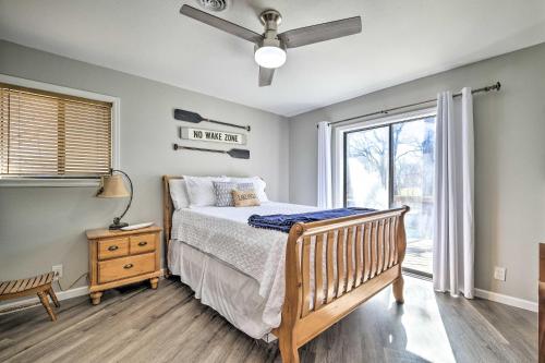a bedroom with a bed with a ceiling fan and a window at Updated Afton Cottage with Dock and Lake Access! in Afton